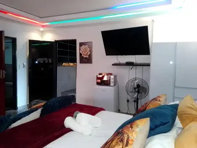 a room with a bed with a tv on the wall at Sbarba guesthouse in Ga-Kgapane