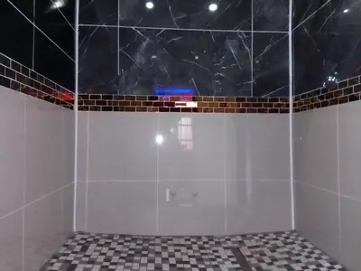a bathroom with a shower with black and white tiles at Sbarba guesthouse in Ga-Kgapane