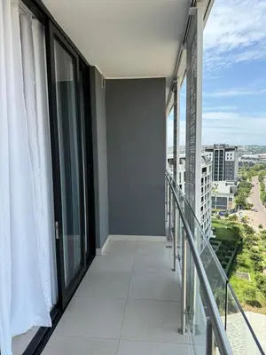 a balcony with glass doors and a view of a city at Ellipse Luxary Apartment in Midrand
