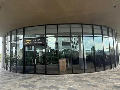 a large glass building with a sign in front of it at Ellipse Luxary Apartment in Midrand