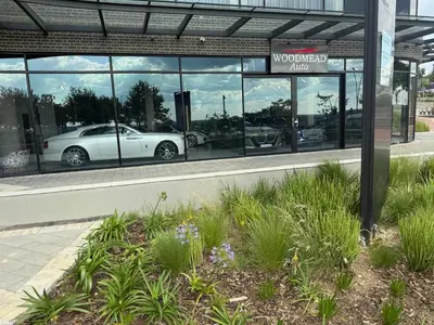 a car dealership with a white car in the window at Ellipse Luxary Apartment in Midrand