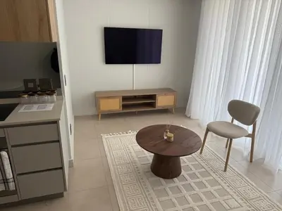 a living room with a table and a tv at Ellipse Luxary Apartment in Midrand