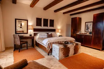 a bedroom with a bed and a desk and a table at Kapama River Lodge in Kapama Private Game Reserve