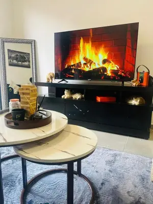 a fireplace in a living room with a table and a fire place at 2 bedroom signature luxury apartment in Midrand