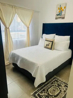 a bedroom with a large bed with a blue headboard at 2 bedroom signature luxury apartment in Midrand