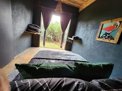 a bedroom with a bed in a room with a window at Hartbeest Bush Stay #2 in Hartbeespoort