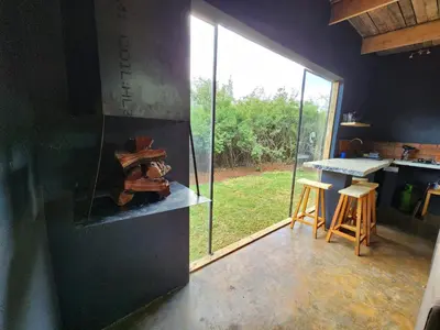 a kitchen with a large window and a table with stools at Hartbeest Bush Stay #2 in Hartbeespoort