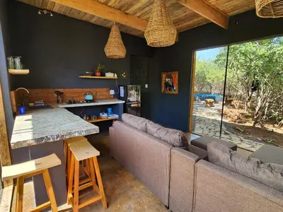 a living room with a couch and a large window at Hartbeest Bush Stay #2 in Hartbeespoort