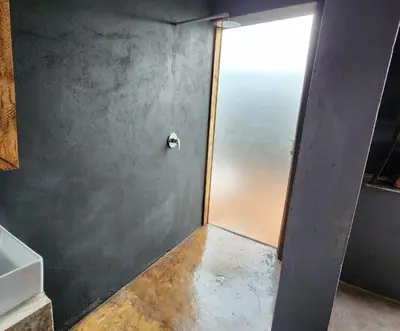 a bathroom with a gray wall and a door at Hartbeest Bush Stay #2 in Hartbeespoort