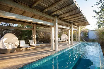 an outdoor swimming pool with a wooden pergola and a swimming poolvisor at Kapama Buffalo Camp in Kapama Private Game Reserve