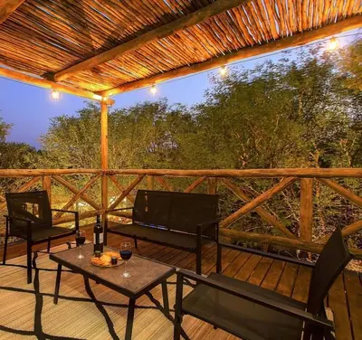 a patio with a table and chairs on a deck at Makrugu Forest in Marloth Park