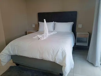 a large white bed with white sheets and pillows at Joyful Home Bela-Bela in Bela-Bela