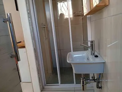 a bathroom with a sink and a shower at Joyful Home Bela-Bela in Bela-Bela