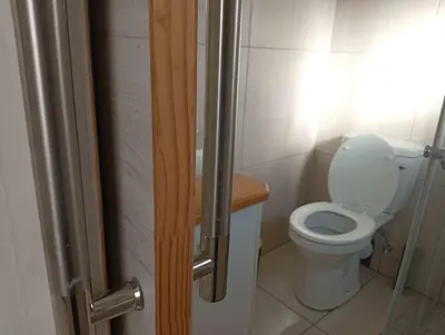 a bathroom with a toilet and a glass shower door at Joyful Home Bela-Bela in Bela-Bela
