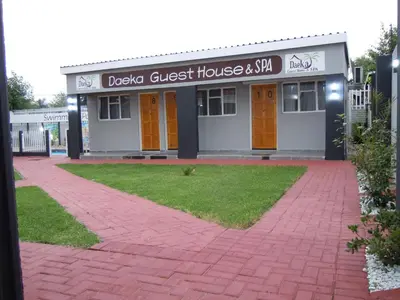 a guest house with orange doors and a brick driveway at Daeka Guesthouse in Kempton Park