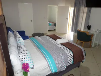 a bedroom with a large bed with pillows on it at Daeka Guesthouse in Kempton Park