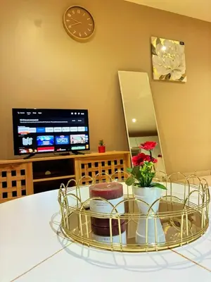 a room with a table with a clock and a tv at Apartment with Breathtakingly Beautiful Lake Views in Pretoria