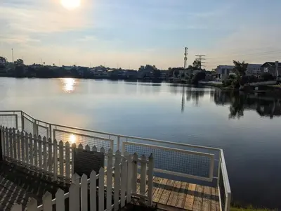 a view of a river with a white fence at Apartment with Breathtakingly Beautiful Lake Views in Pretoria