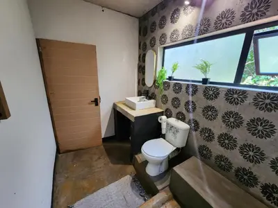 a bathroom with a toilet and a sink and a window at Hartbeest Bush Stay #30 in Hartbeespoort