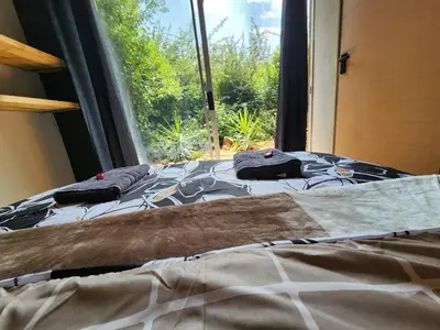 two beds in a room with a window at Hartbeest Bush Stay #27 in Hartbeespoort