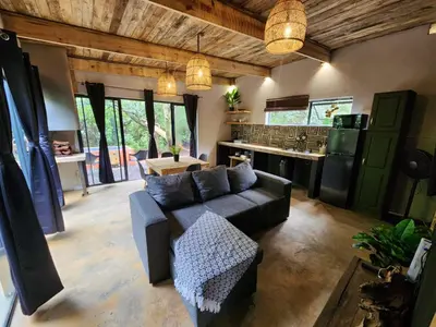 a living room with a couch and a kitchen at Hartbeest Bush Stay #25 in Hartbeespoort