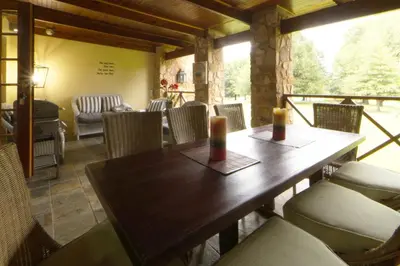 a dining room with a wooden table and chairs at Elgin Farm Dullstroom in Dullstroom