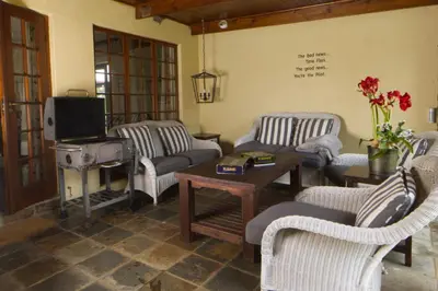 a living room with couches and a tv and a table at Elgin Farm Dullstroom in Dullstroom