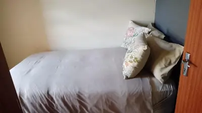 a bed with two pillows on top of it at Tshepang Modern Suites Secunda in Secunda