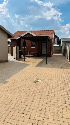 a brick house with a brick driveway in front of it at Tshepang Modern Suites Secunda in Secunda
