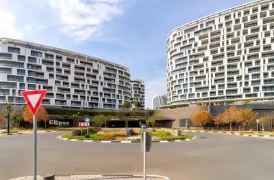 a large building with a yield sign in a parking lot at 4TEN15 Deluxe at Galileo, Ellipse in Midrand