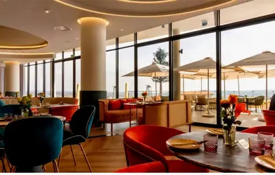 a restaurant with red chairs and tables and windows at 4TEN15 Deluxe at Galileo, Ellipse in Midrand