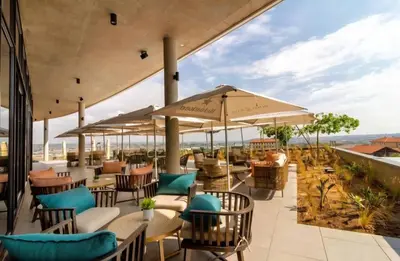 a patio with chairs and tables and umbrellas at 4TEN15 Deluxe at Galileo, Ellipse in Midrand