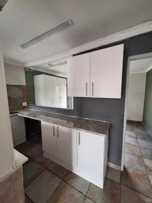 a kitchen with white cabinets and a large mirror at Kinross house in Evander