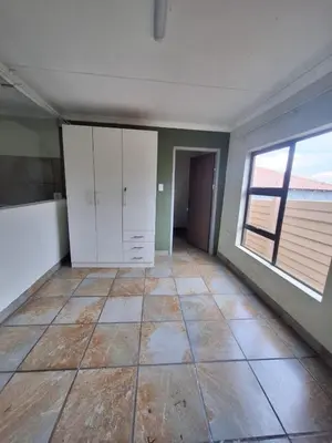 an empty room with white cabinets and a window at Kinross house in Evander