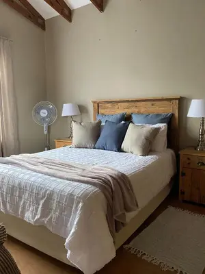 a bedroom with a large bed with blue pillows at Inn Da Bush in Nelspruit