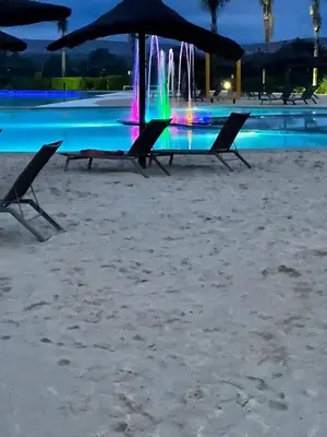 a table and chairs on the beach with a fountain at The Exquisite apartment at its best ! in Pretoria