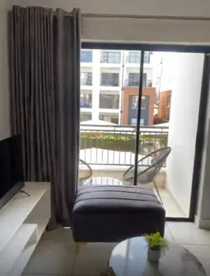 a living room with a couch and a large window at The Exquisite apartment at its best ! in Pretoria