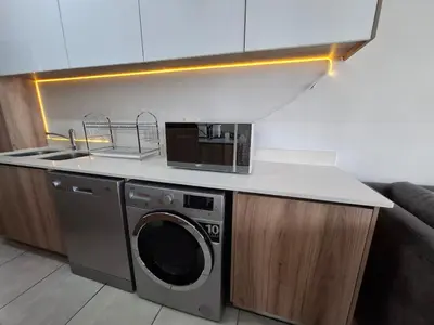 a kitchen with a washing machine and a sink at Spectacular Lagoon Facing Apartment - The Blyde in Pretoria
