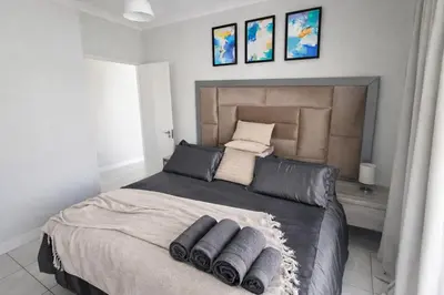 a bedroom with a large bed with three pillows at Spectacular Lagoon Facing Apartment - The Blyde in Pretoria