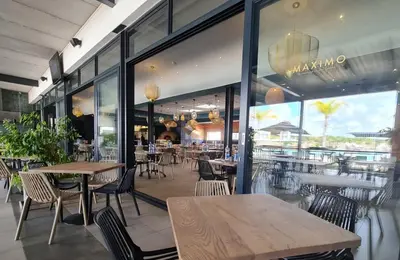 a restaurant with tables and chairs and a large window at Spectacular Lagoon Facing Apartment - The Blyde in Pretoria