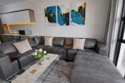 a living room with a couch and a table at Spectacular Lagoon Facing Apartment - The Blyde in Pretoria