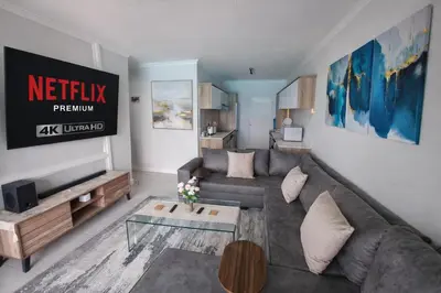 a living room with a couch and a table at Spectacular Lagoon Facing Apartment - The Blyde in Pretoria