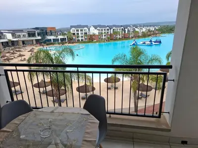 a balcony with a view of a large pool at Spectacular Lagoon Facing Apartment - The Blyde in Pretoria