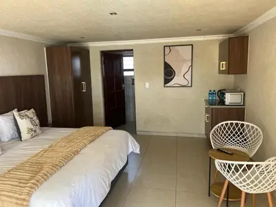 a hotel room with a bed and a table and chairs at Village Walk Guesthouse
