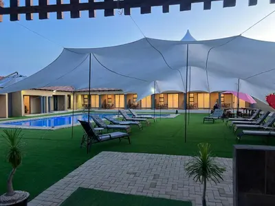 a large tent with lounge chairs and a swimming pool at Village Walk Guesthouse