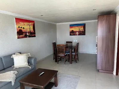 a living room with a couch and a table at Village Walk Guesthouse