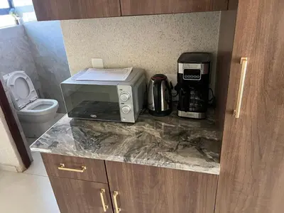 a kitchen counter with a microwave and a toaster at Village Walk Guesthouse