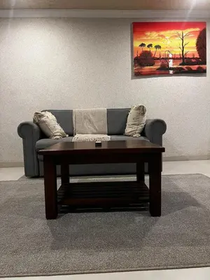 a couch with a coffee table in a living room at Village Walk Guesthouse
