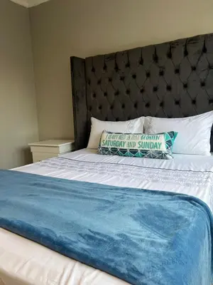 a bed with a blue and white blanket and pillows at Garden Flat to rent in Pretoria