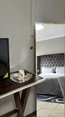 a room with a bed and a table with a tray at Garden Flat to rent in Pretoria